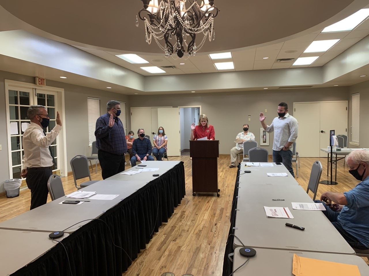 A woman swears in three men